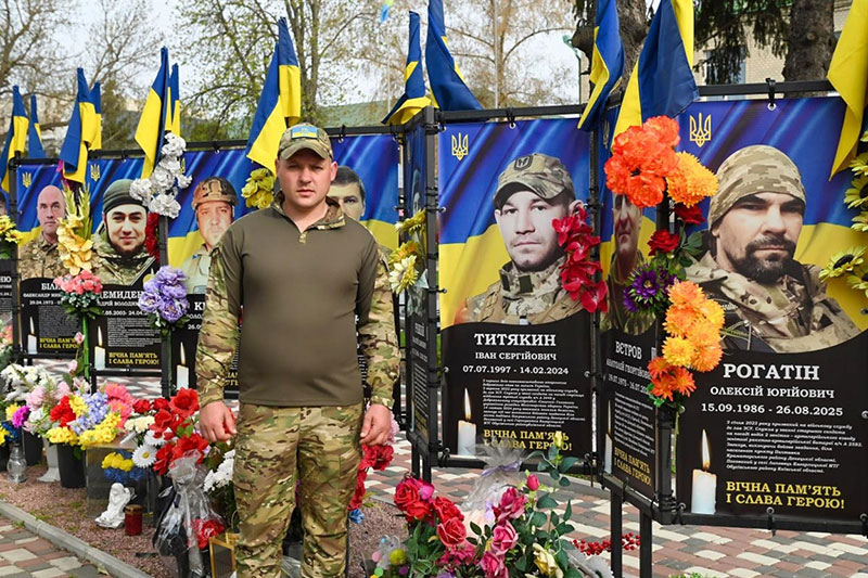 Роман Цівун на Алеї Слави Героїв у Кагарлику біля банера з портретом свого племінника, полеглого воїна Івана Титякина